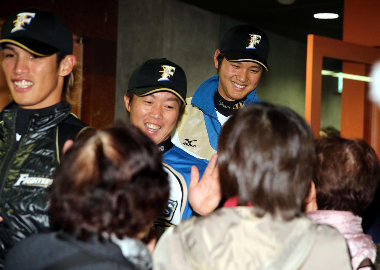 2013年、ファンとウエルカムハイタッチする大谷（右）らナイン