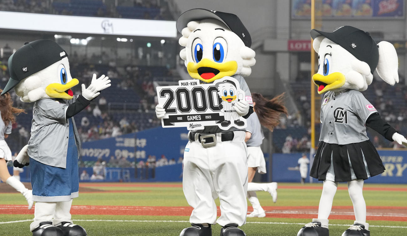 ロッテ対楽天　主催2000試合出場のマーくん（中央）はボードを掲げる（撮影・鈴木みどり）