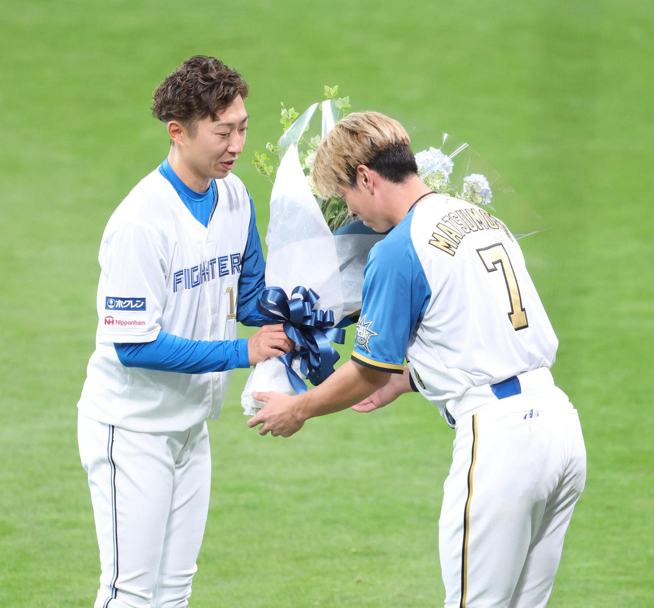 日本ハム対オリックス　試合前、日本ハム金子特命コーチ（左）は引退セレモニーで松本剛から花束を受け取る（撮影・佐藤翔太）