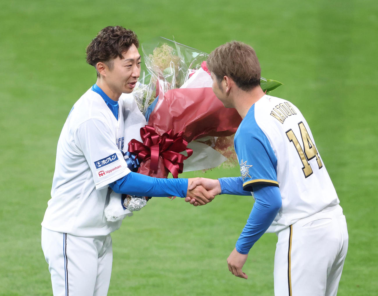 日本ハム対オリックス　試合前、日本ハム金子特命コーチ（左）は引退セレモニーで加藤貴から花束を受け取る（撮影・佐藤翔太）