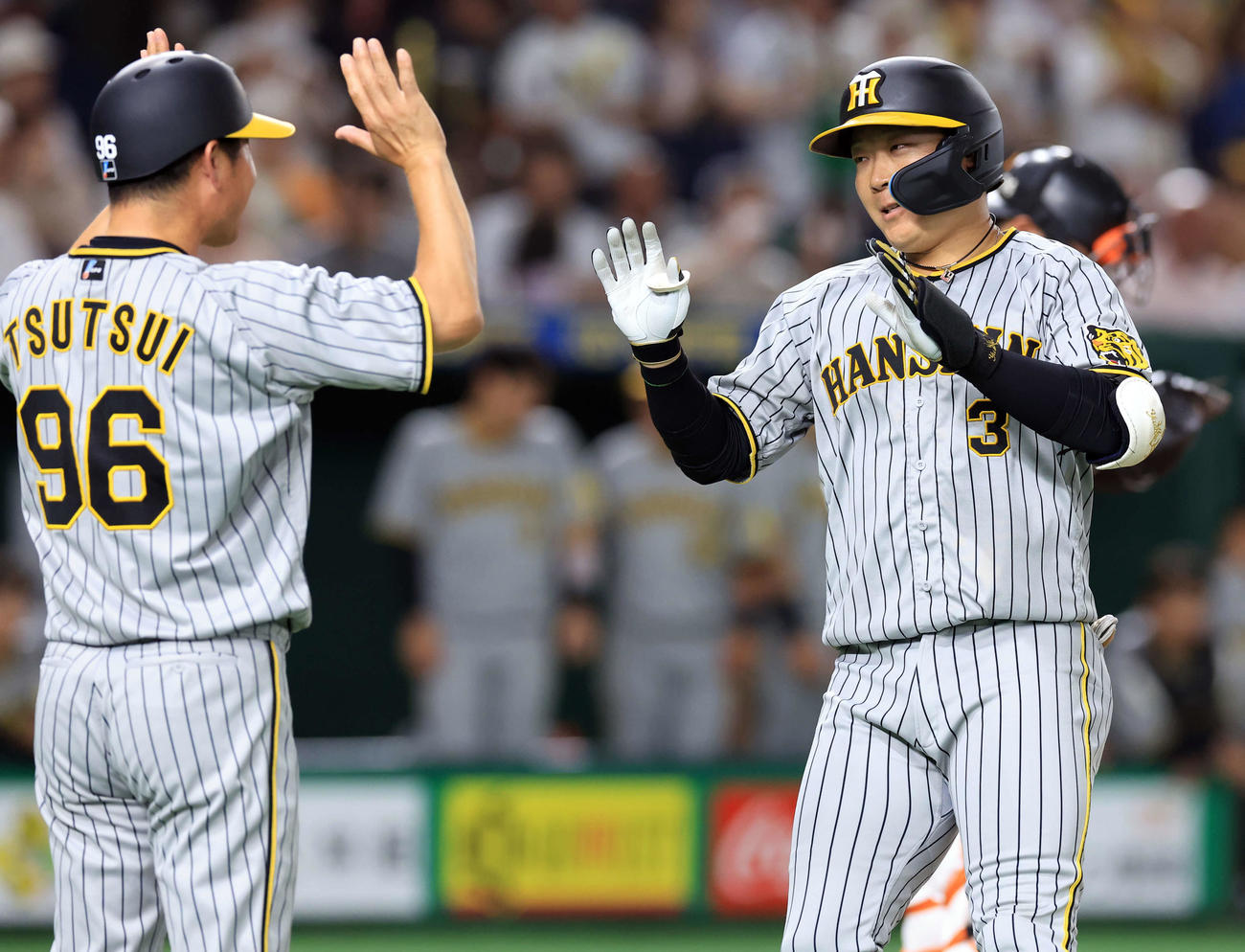 巨人対阪神　4回表阪神2死、大山（右）は左中間ソロ本塁打を放ち、笑顔のハイタッチで生還する（撮影・浅見桂子）