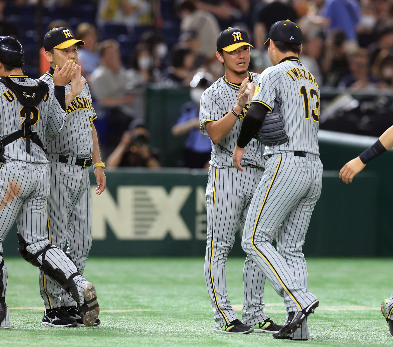 巨人対阪神　勝利投手の伊藤将（右から2人目）は岩崎からウイニングボールを受け取る。左は岡田監督（撮影・浅見桂子）