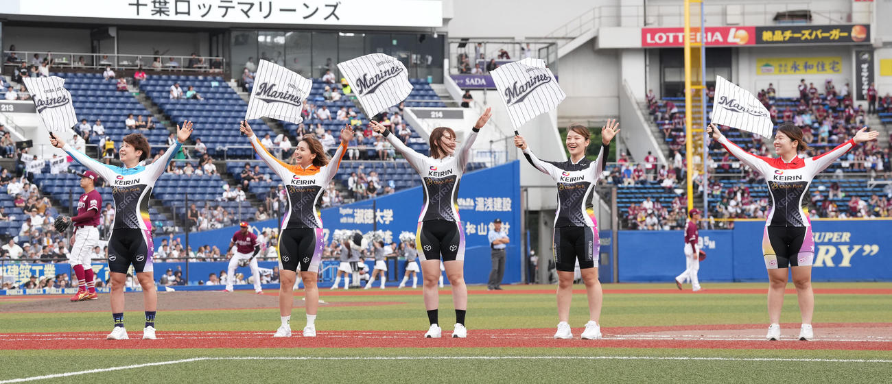 ロッテ対楽天　7回裏前、フラッグを振る柳原（左）らガールズケイリンの選手たち（撮影・鈴木みどり）