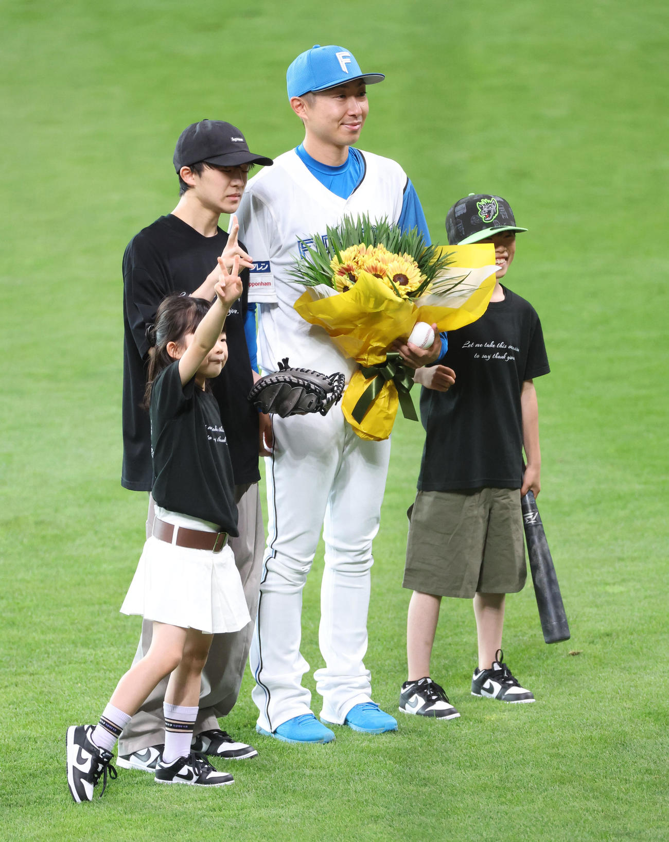 日本ハム対オリックス　試合前、引退セレモニーを終え子供たちと記念撮影をする日本ハム金子特命コーチ（撮影・佐藤翔太）