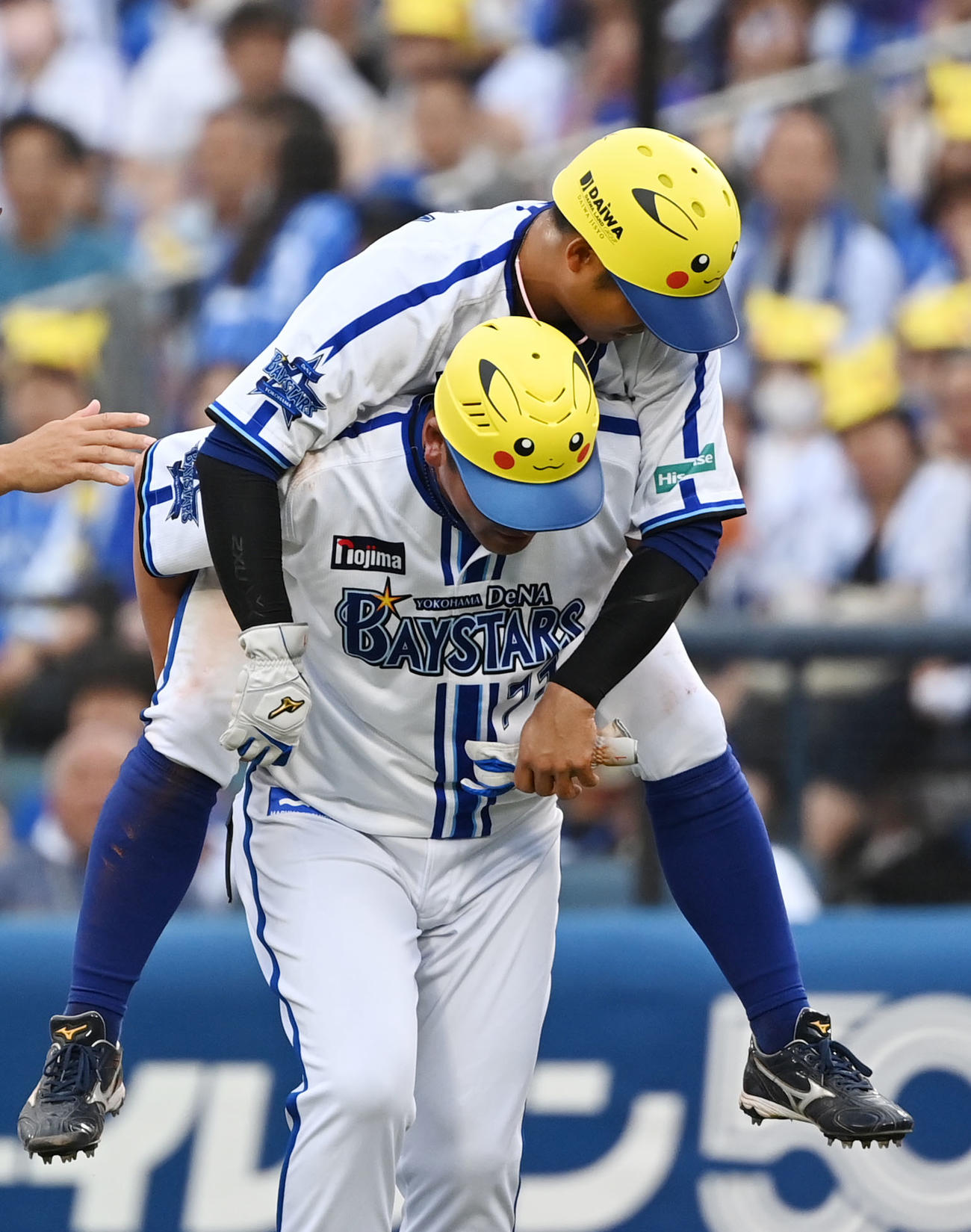走塁中にけがをしアウトとなった桑原（右）は小池コーチにおぶられグラウンドを後にする（2023年7月1日撮影）