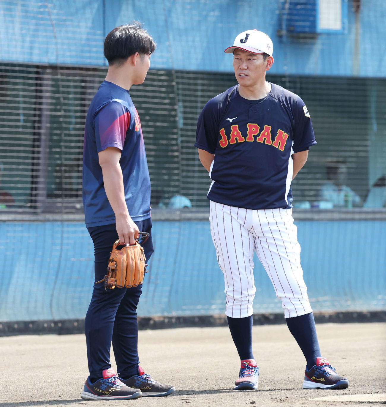 大学日本代表・玉井マネジャー（左）と話す井端臨時コーチ（撮影・宮地輝）