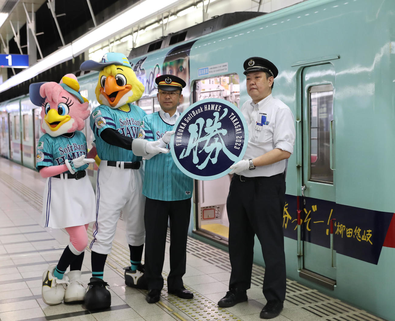 オリジナルヘッドマークを授与し記念撮影に納まる、左からハニーホーク、ハリーホーク、野口駅長(撮影・冨田成美)