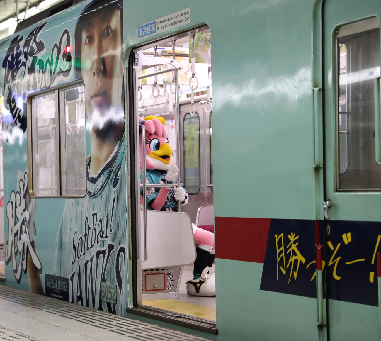 鷹の祭典2023特別デザインの西鉄ラッピング電車「勝つぞー！電車」に乗るハニーホーク(撮影・冨田成美)