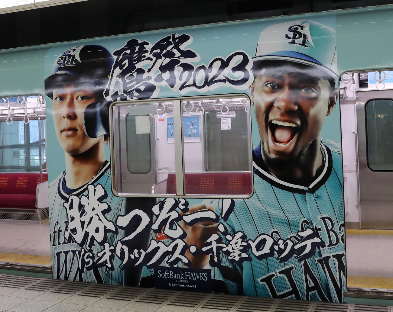 鷹の祭典2023特別デザインの西鉄ラッピング電車「勝つぞー！電車」にラッピングされた今宮(左)とモイネロ(撮影・冨田成美)