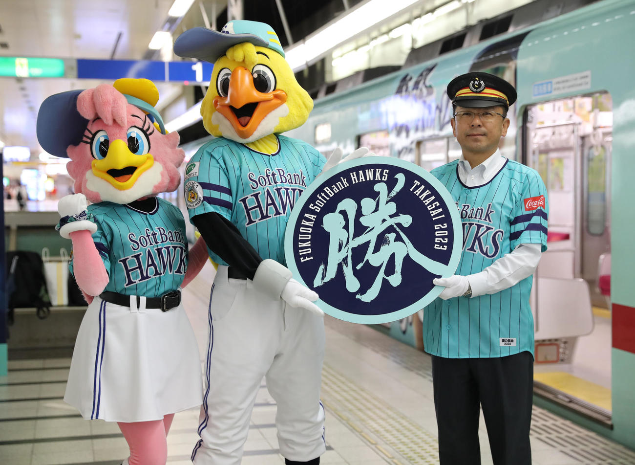 オリジナルヘッドマークを手に記念撮影に納まる、右から野口駅長、ハリーホーク、ハニーホーク(撮影・冨田成美)