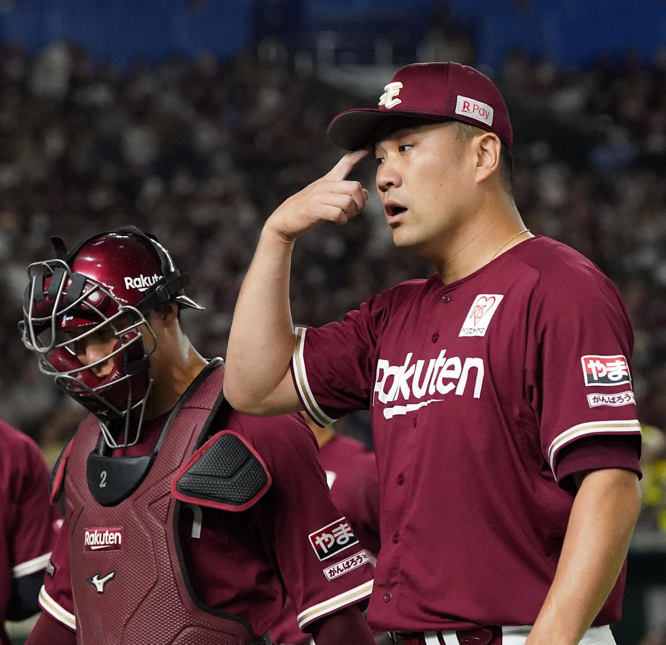 楽天対オリックス　1回表を終え、太田（左）と話しながら、険しい表情でベンチに戻る先発の田中将（撮影・狩俣裕三）