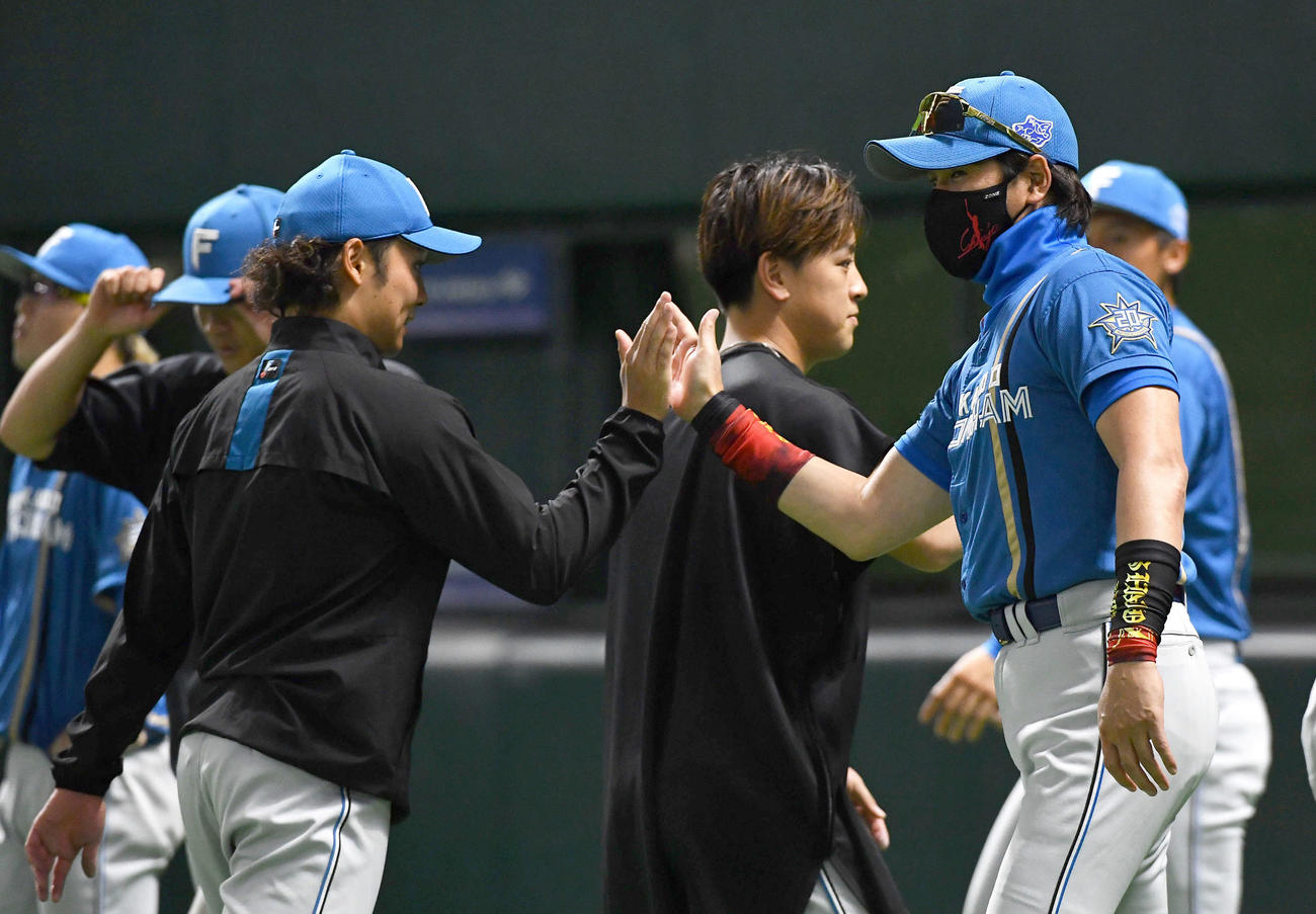 ソフトバンク対日本ハム　ソフトバンクに勝利し、今季5勝目を挙げた伊藤（左）とタッチを交わす新庄監督（撮影・岩下翔太）