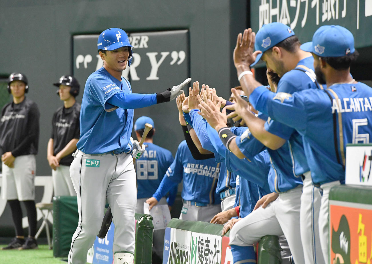 ソフトバンク対日本ハム　2回表日本ハム無死、左越えソロ本塁打を放った郡司（左）はチームメートとタッチを交わす（撮影・岩下翔太）