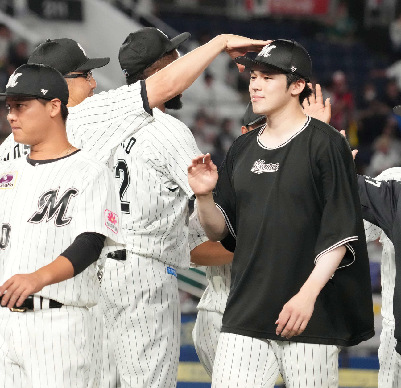 ロッテ対西武　8回無失点の好投で今季6勝目を挙げたロッテ佐々木朗（右）は吉井監督に頭を軽くたたかれて笑顔を見せる（撮影・小沢裕）
