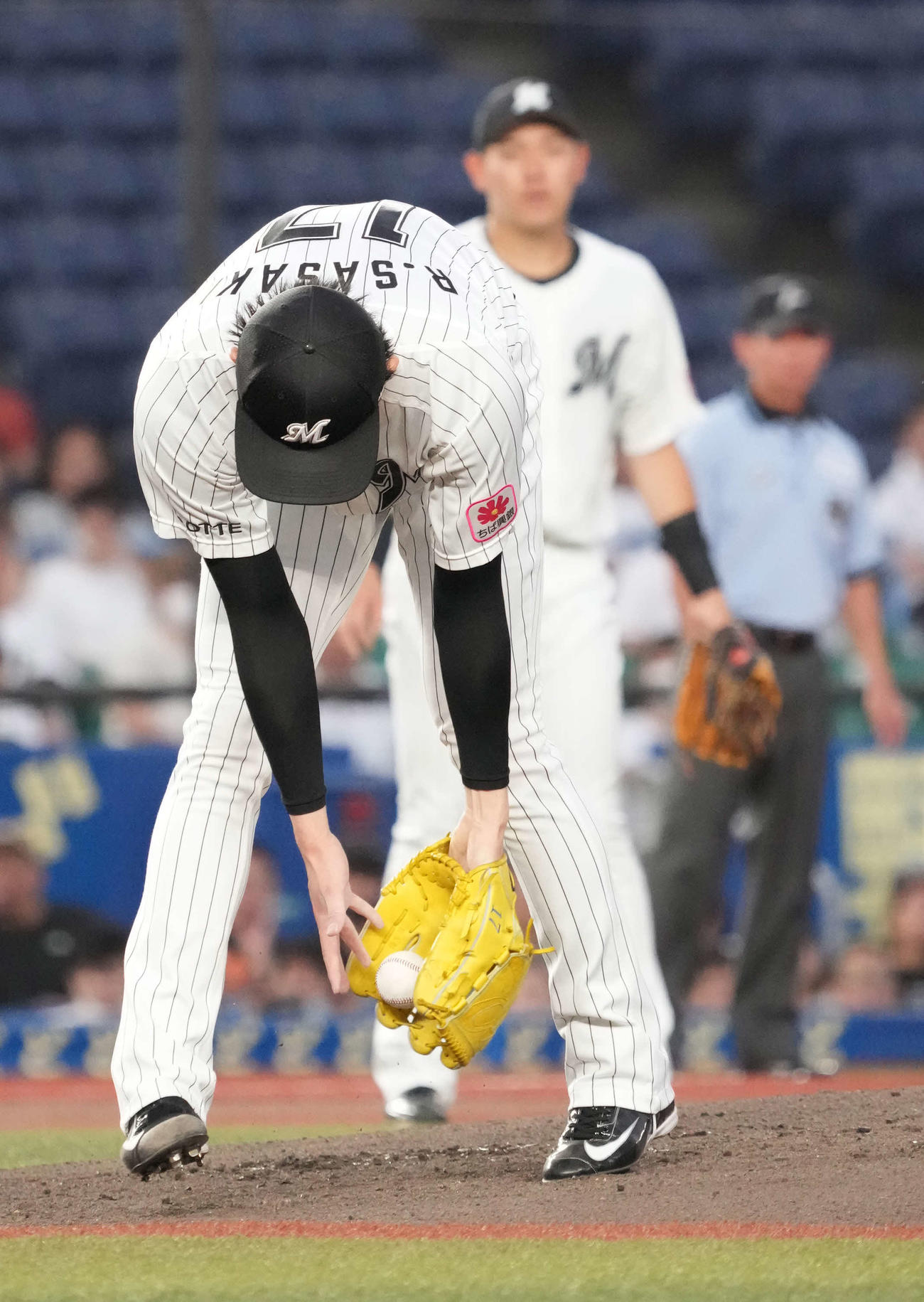 ロッテ対西武　3回表西武1死、ロッテ先発の佐々木朗はクラブからこぼれた源田の投ゴロを拾い直し一塁へトスする（撮影・小沢裕）