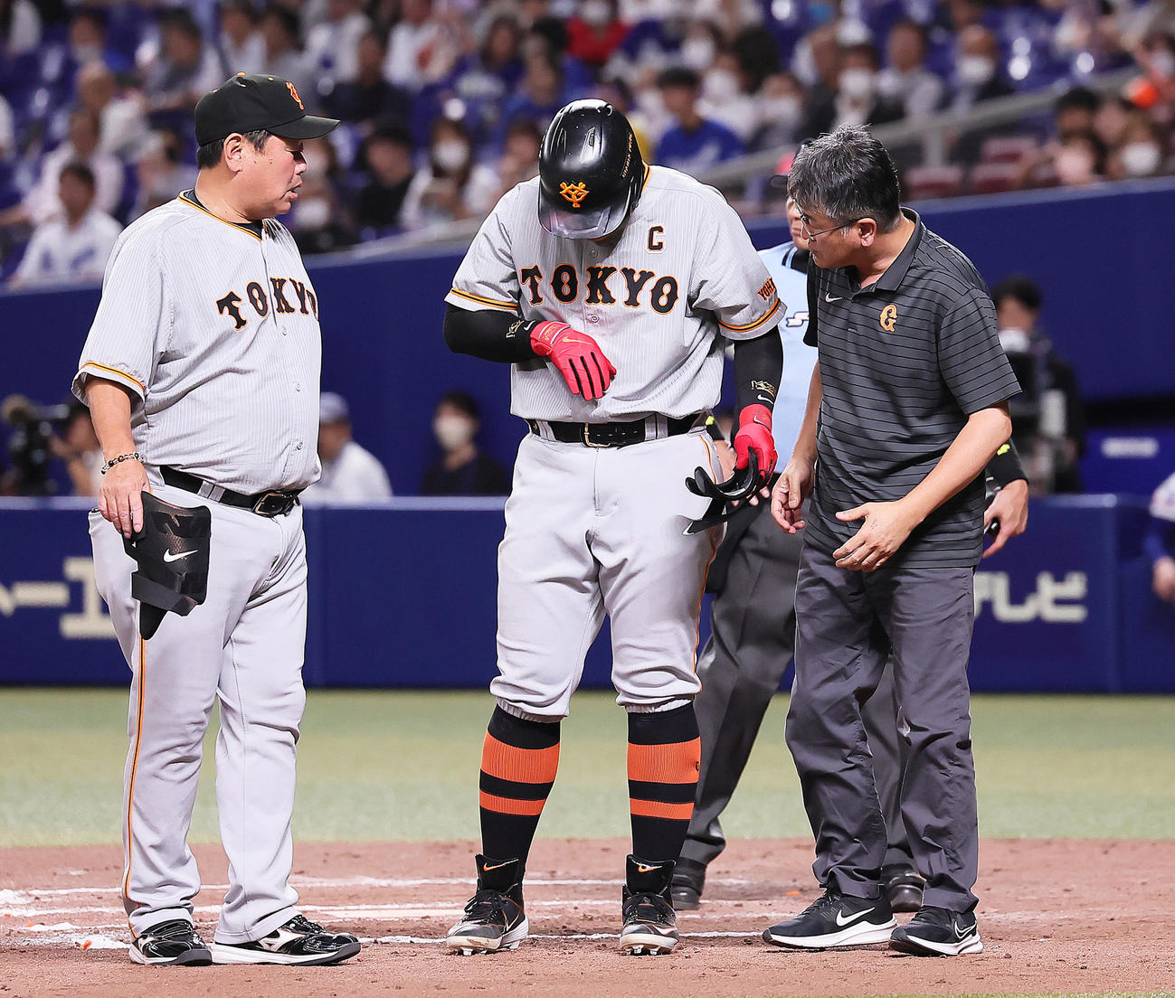 中日対巨人　12回表巨人無死一塁、右手に死球を受けた岡本和（中央）（撮影・足立雅史）