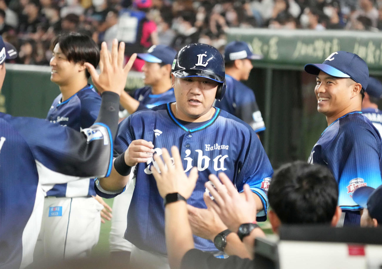 ロッテ対西武　7回表西武2死一、二塁、岸の勝ち越し左前適時打で生還した中村（中央）はベンチのナインの祝福を受ける（撮影・小沢裕）