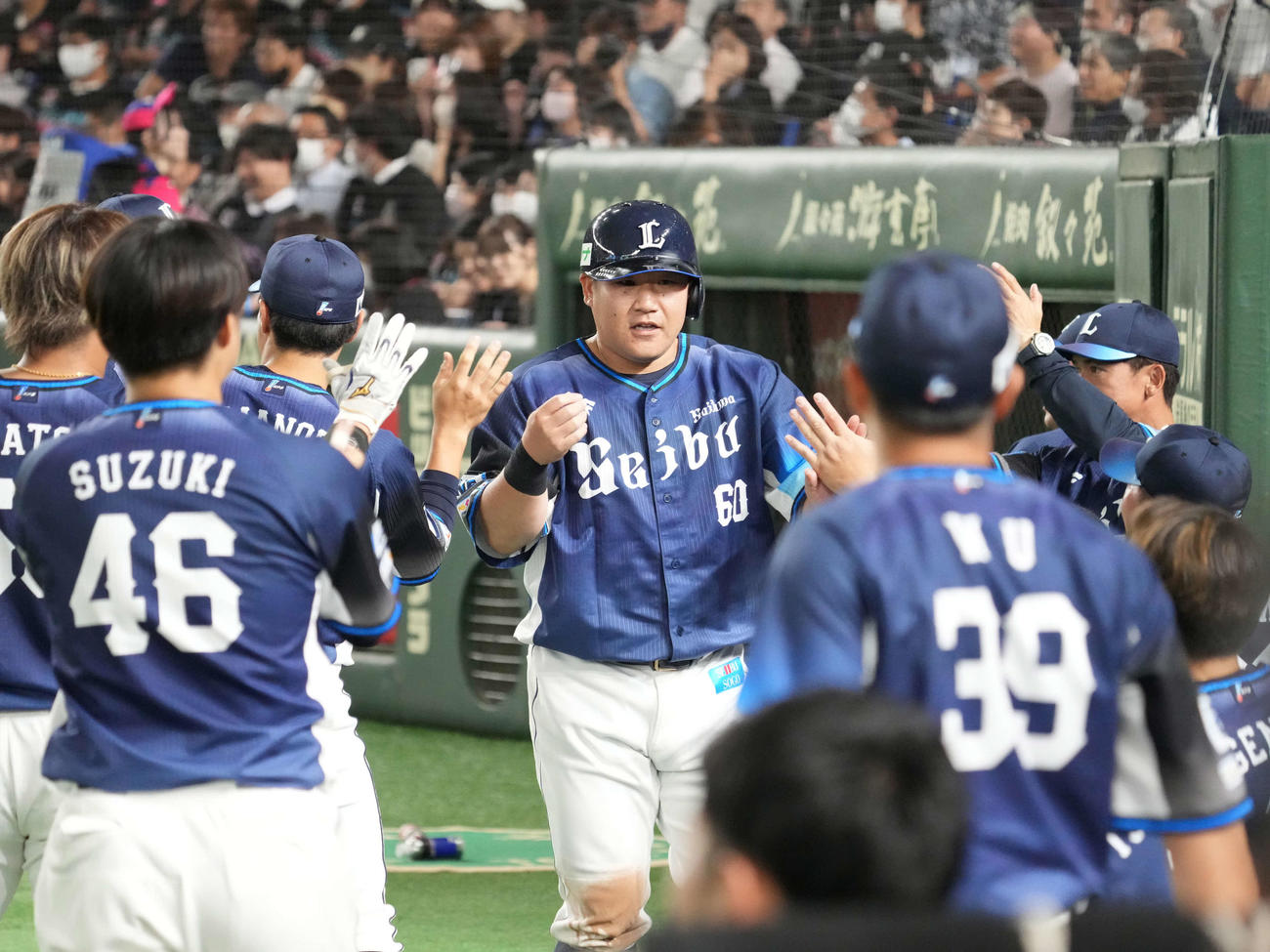 ロッテ対西武　7回表西武2死一、二塁、岸の勝ち越し左前適時打で生還した中村（中央）はベンチのナインの祝福を受ける。右奥は松井監督（撮影・小沢裕）