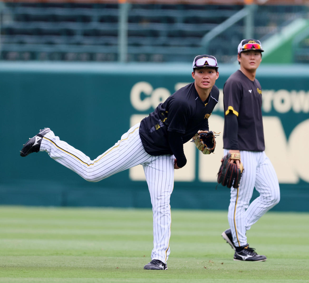 前川（右）とともに外野ノックを受け返球する阪神森下（撮影・加藤哉）