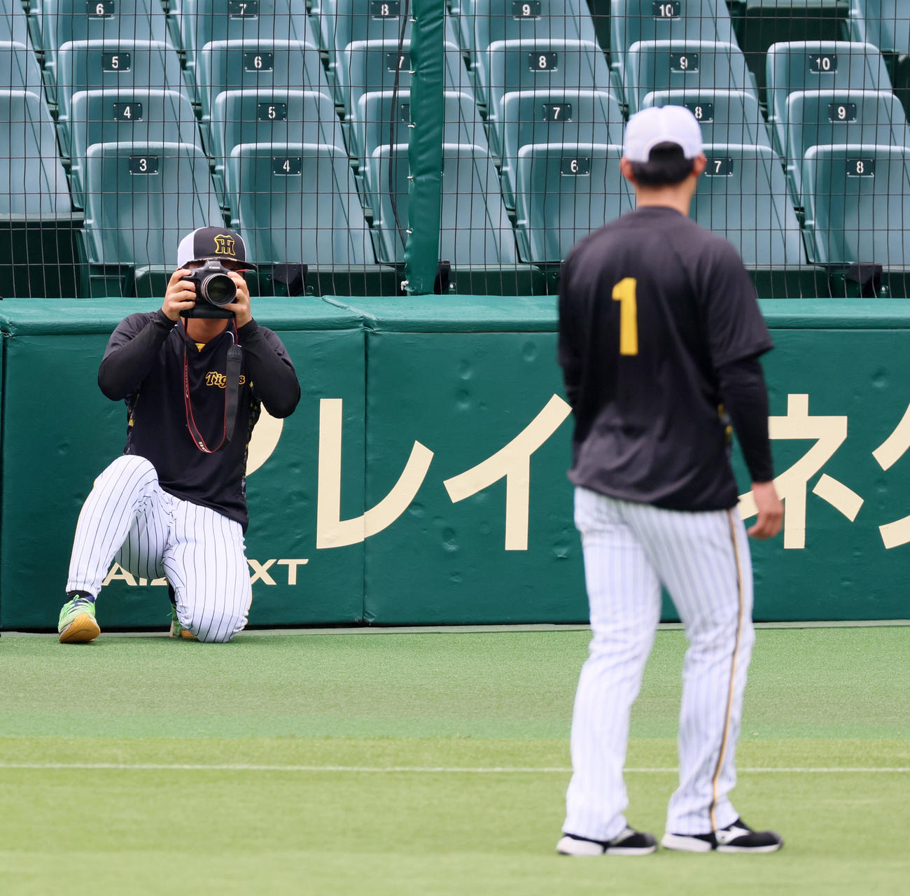 阪神対ヤクルト　違うレンズのカメラを手にモデル役の？森下を撮影する前川（撮影・加藤哉）