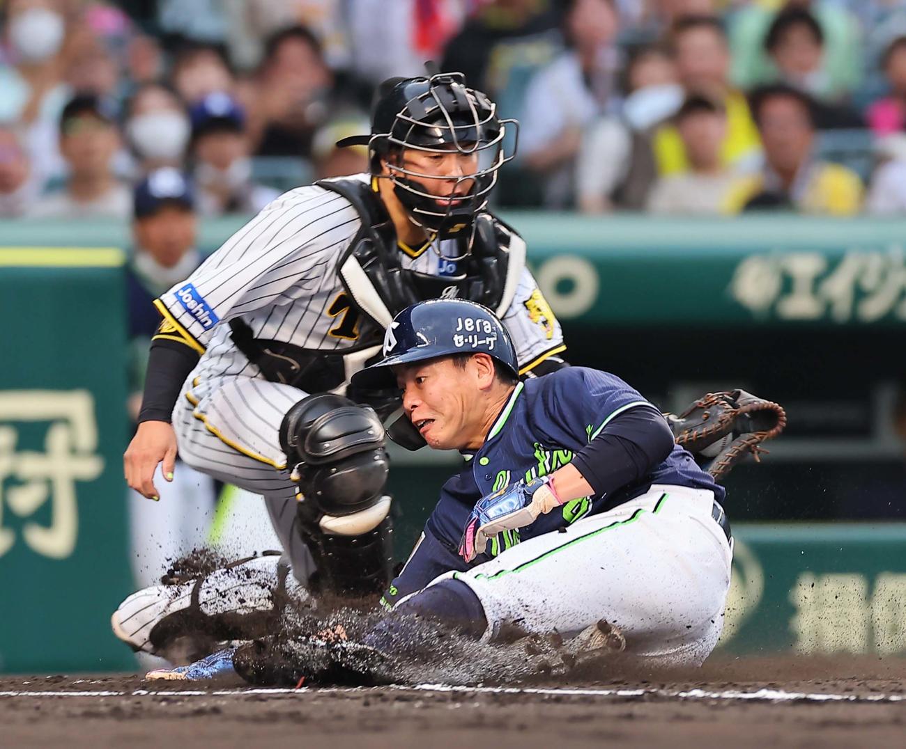 阪神対ヤクルト　1回表ヤクルト1死一、三塁、山崎は村上の左犠飛で生還する。捕手は梅野（撮影・上田博志）
