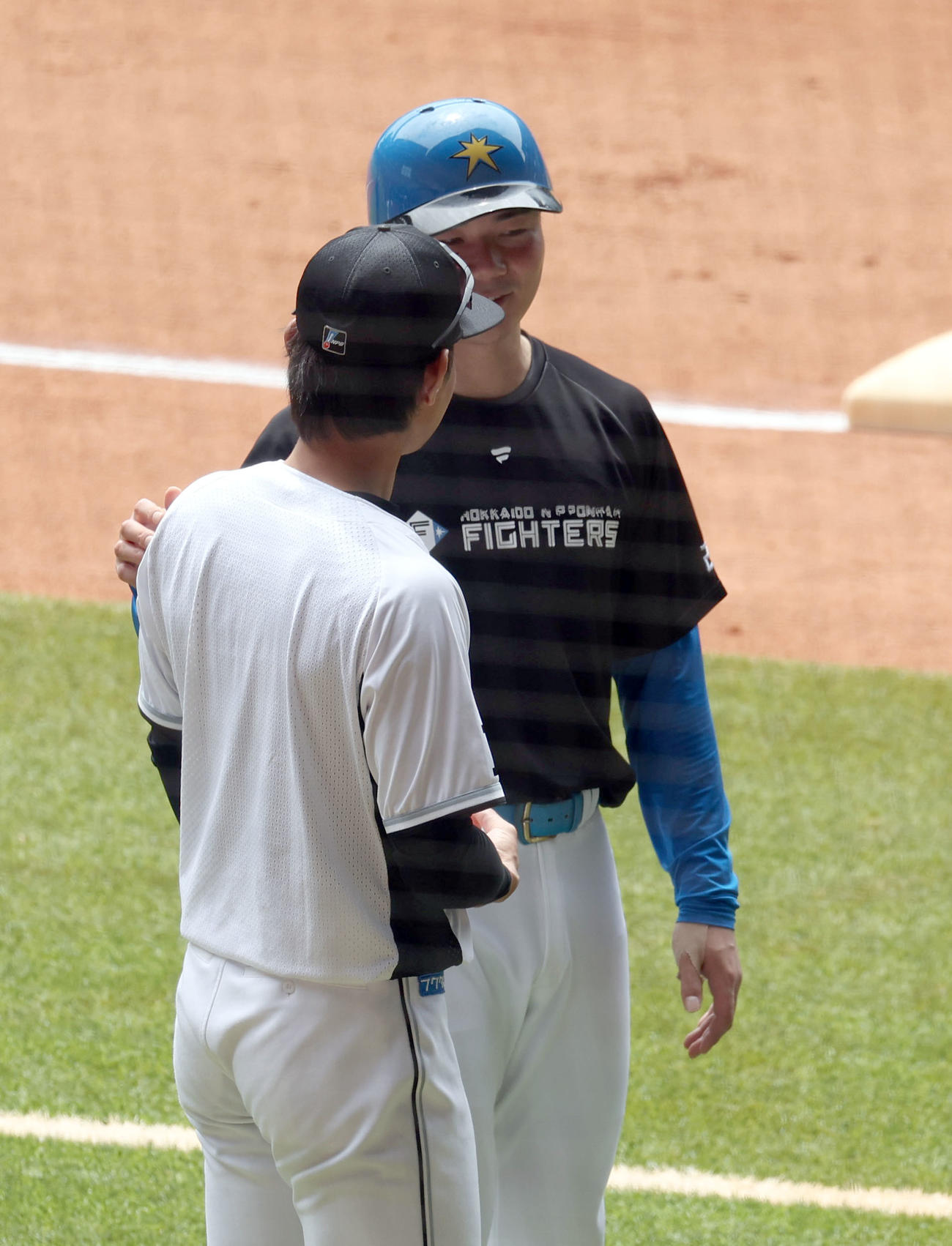 日本ハム対ロッテ　試合前、会話する日本ハム清宮（後方）とロッテ藤原（撮影・佐藤翔太）