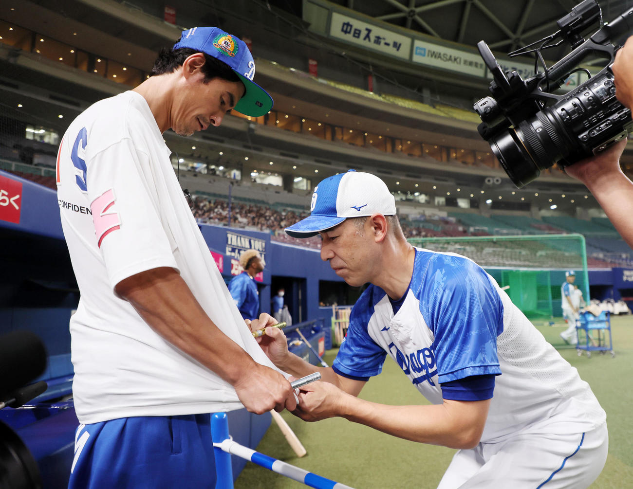 中日対広島　俳優の伊藤英明（左）にサインする和田コーチ（撮影・加藤哉）