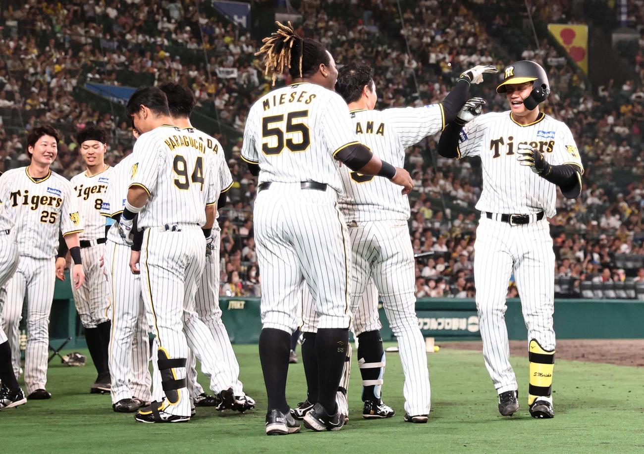 阪神対ヤクルト　8回裏阪神無死、左中間へプロ初本塁打を放った森下はナインの出迎えを受ける（撮影・上田博志）