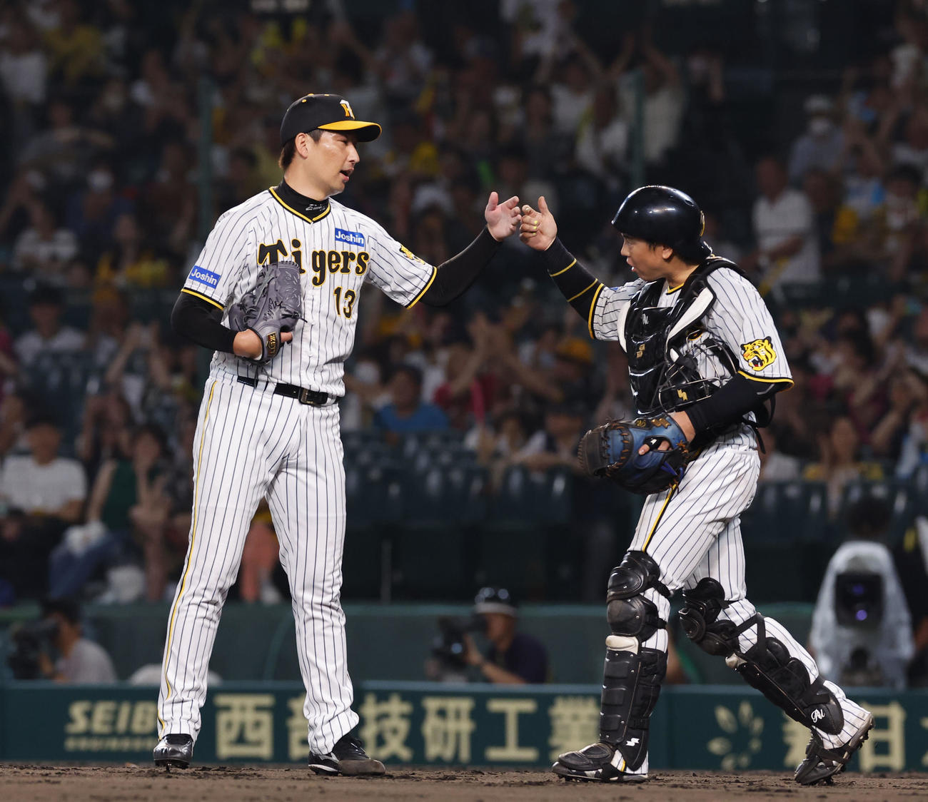 阪神対ヤクルト　ヤクルトに勝利し、タッチを交わす阪神岩崎（左）と梅野（撮影・藤尾明華）