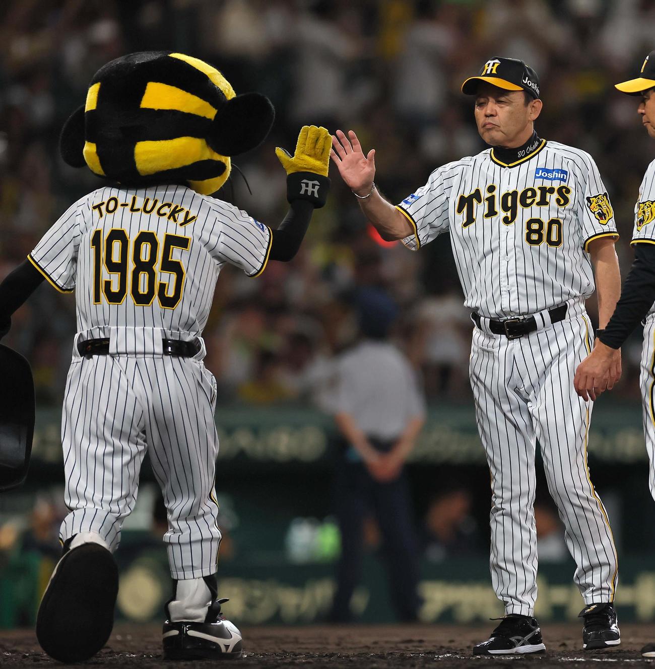 トラッキー（左）とハイタッチをする岡田監督（2023年7月9日撮影）