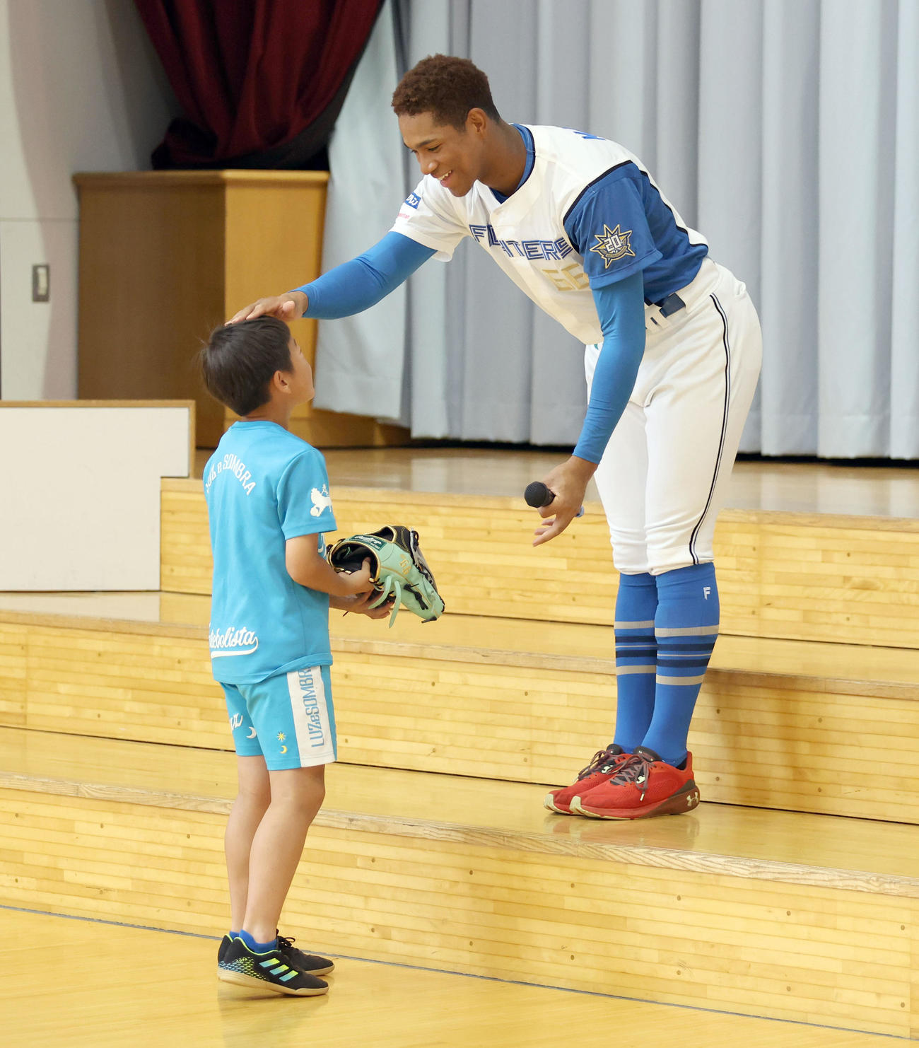 北広島西部小学校を訪れじゃんけんで勝ち残った児童にグラブをプレゼントする日本ハム万波（撮影・佐藤翔太）