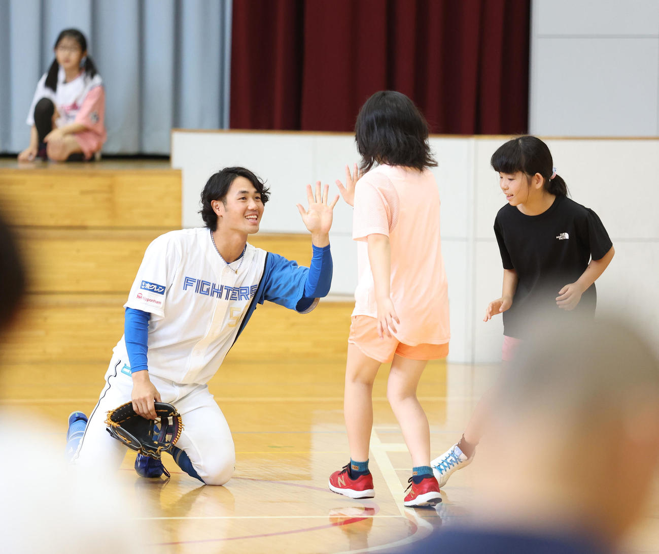 北広島西部小学校を訪れ児童たちとキャッチボールを終えハイタッチをする日本ハム細川（撮影・佐藤翔太）