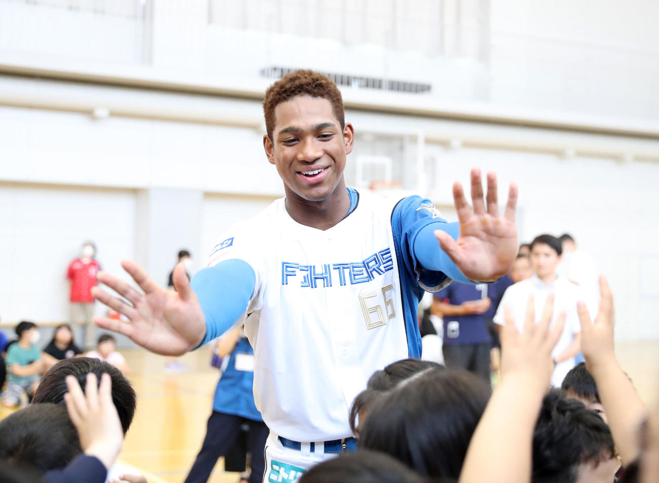 北広島西部小学校を訪れ児童たちとハイタッチをする日本ハム万波（撮影・佐藤翔太）