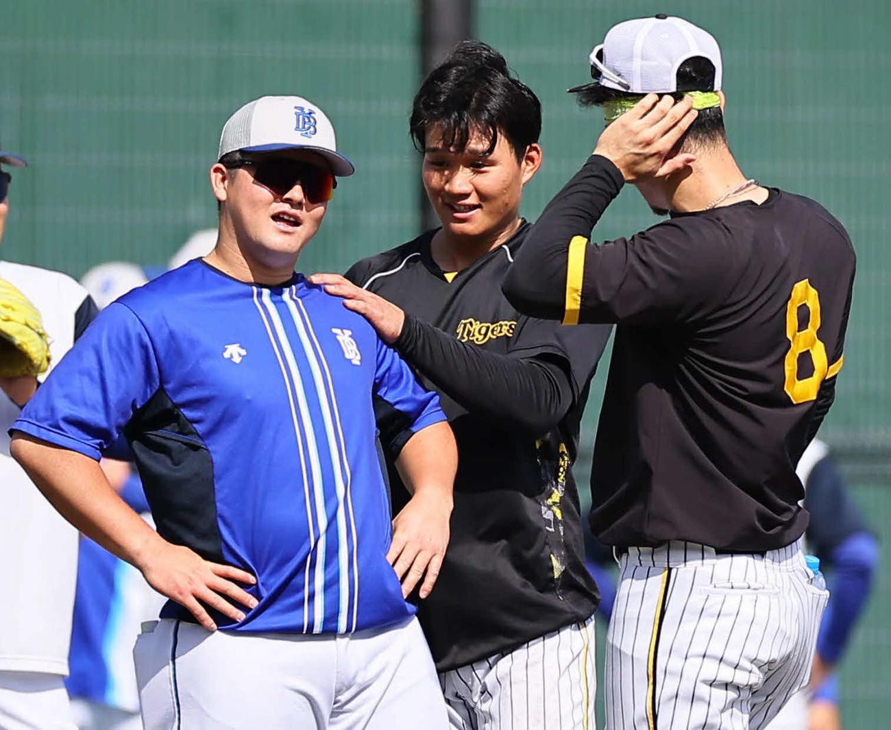 阪神対DeNA　中大の後輩森下（中）を無視して佐藤輝（右）と話をするDeNA牧（撮影・上田博志）