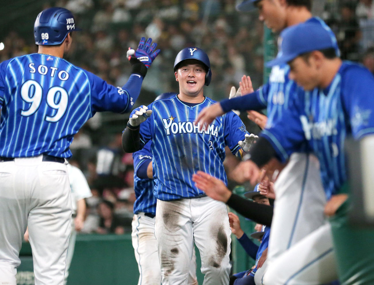 阪神対DeNA 5回表DeNA1死一塁、牧（中央）は左越え2点本塁打を放ちナインの祝福を受ける（撮影・上山淳一）