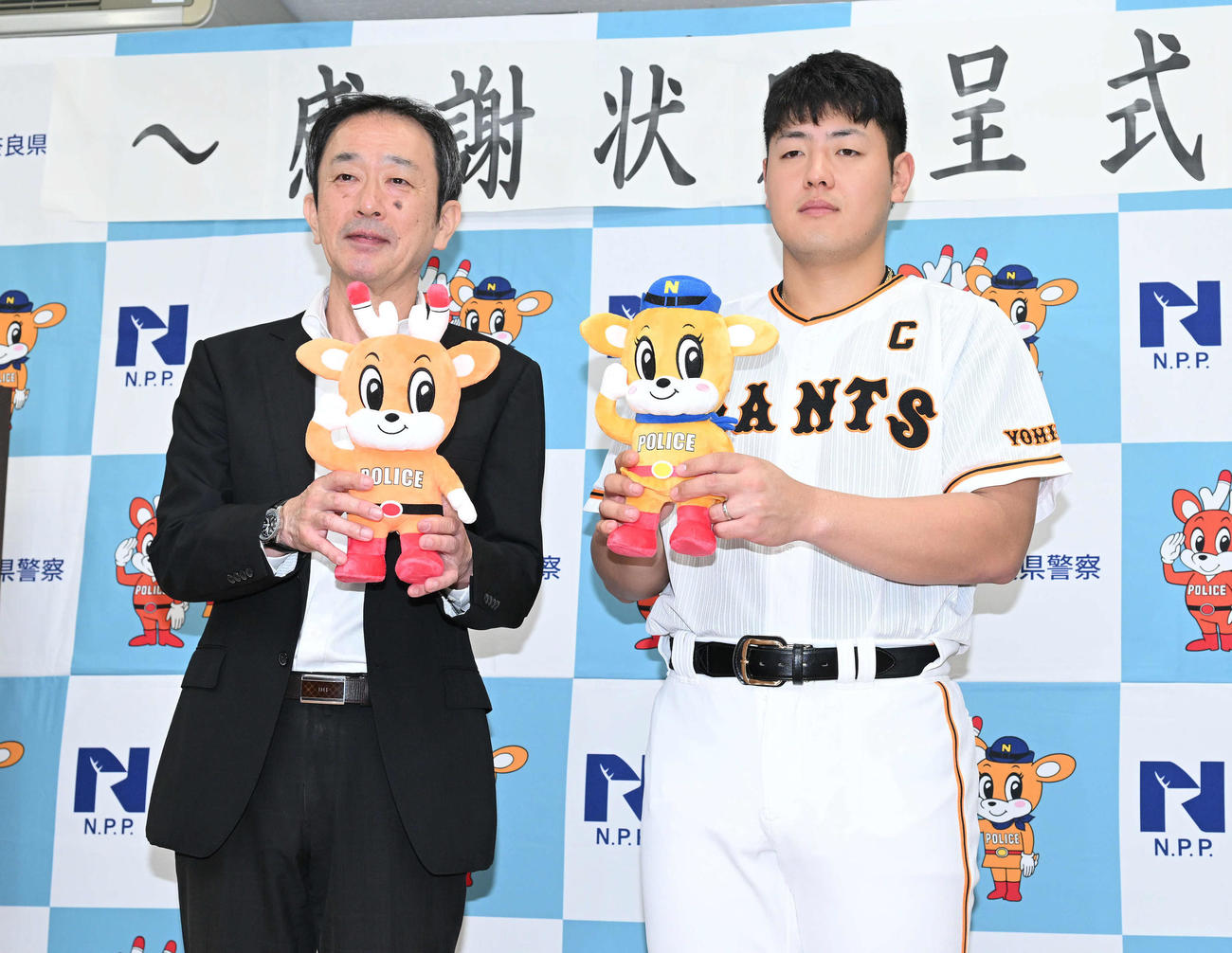 奈良県警から感謝状を贈呈された巨人岡本和は猪原正義生活安全部長と記念撮影する（撮影・滝沢徹郎）