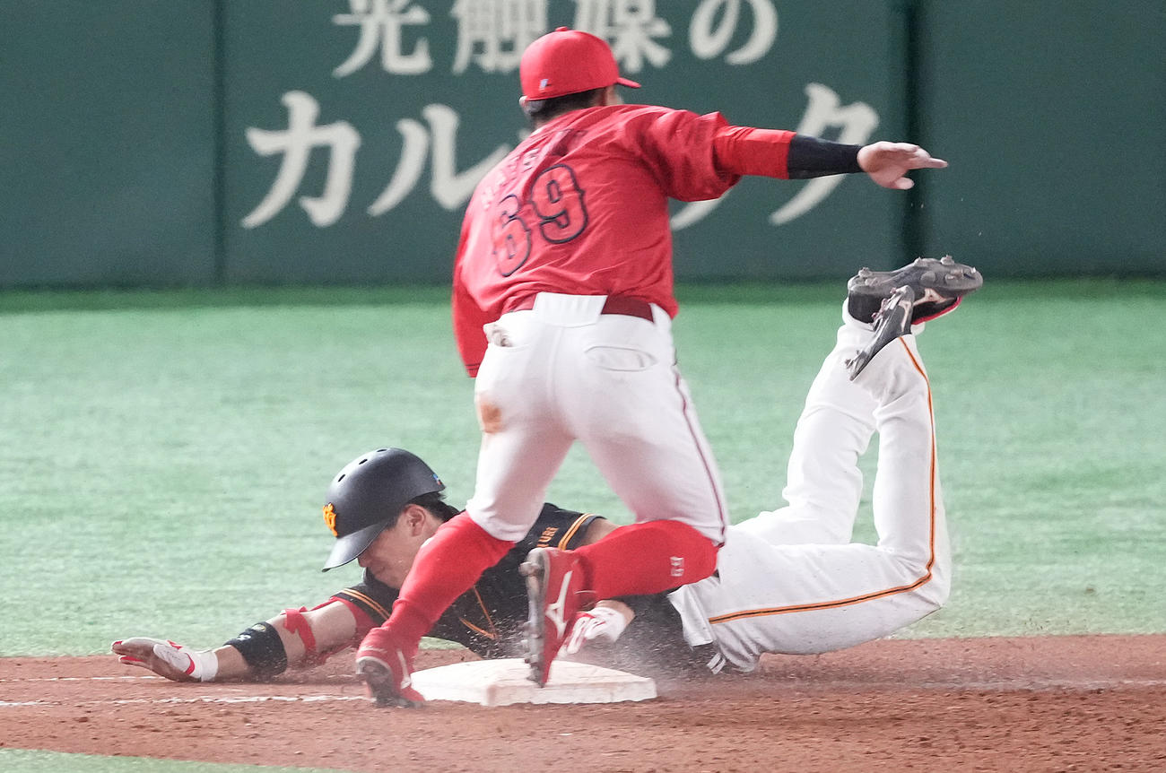 巨人対広島　9回裏巨人無死、内野安打を放ち、一塁へヘッドスライディングする門脇。一塁カバーは二塁手羽月（撮影・鈴木みどり）
