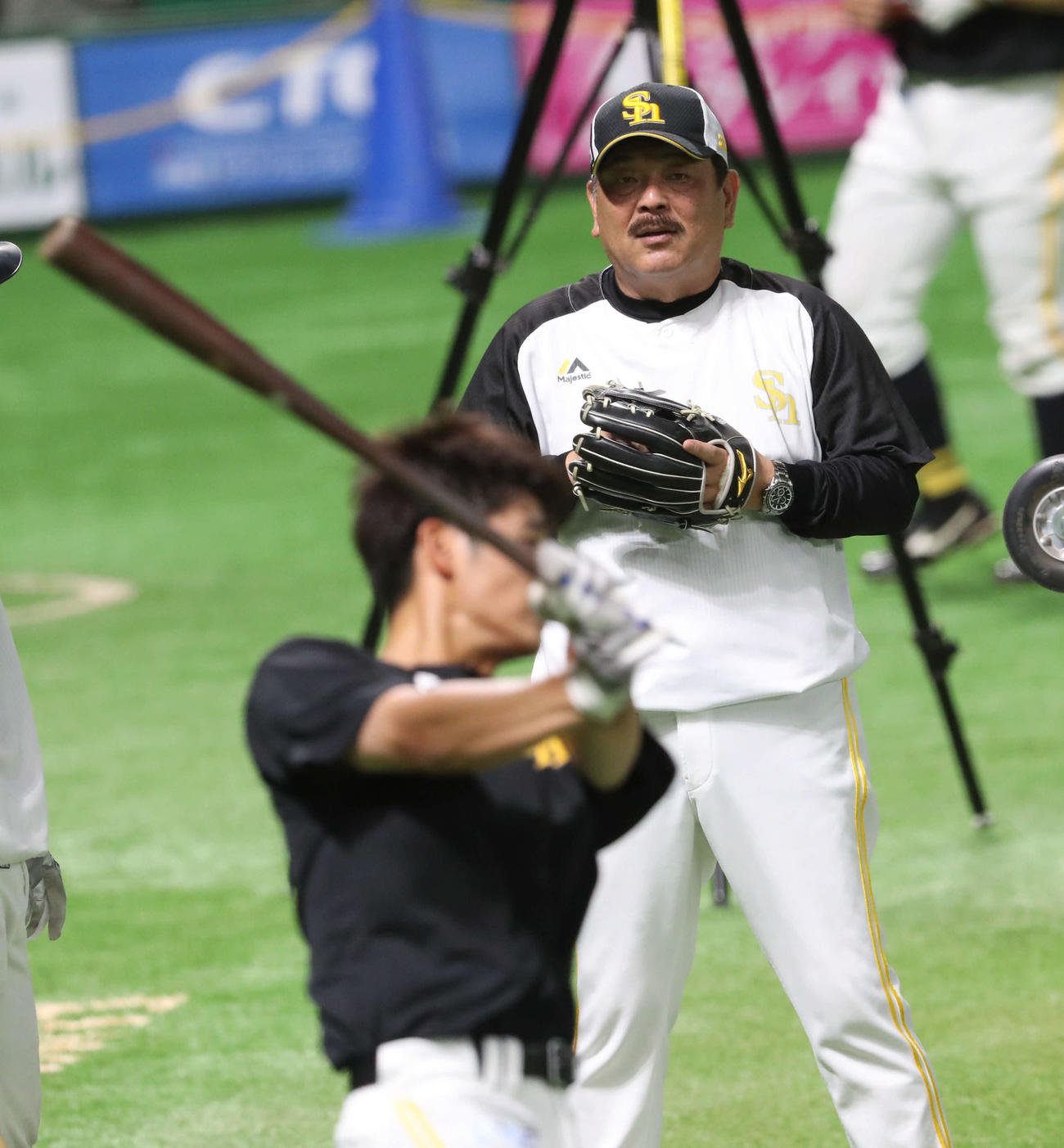 ロングティーで汗を流す上林（手前）を見守る藤本監督（撮影・梅根麻紀）