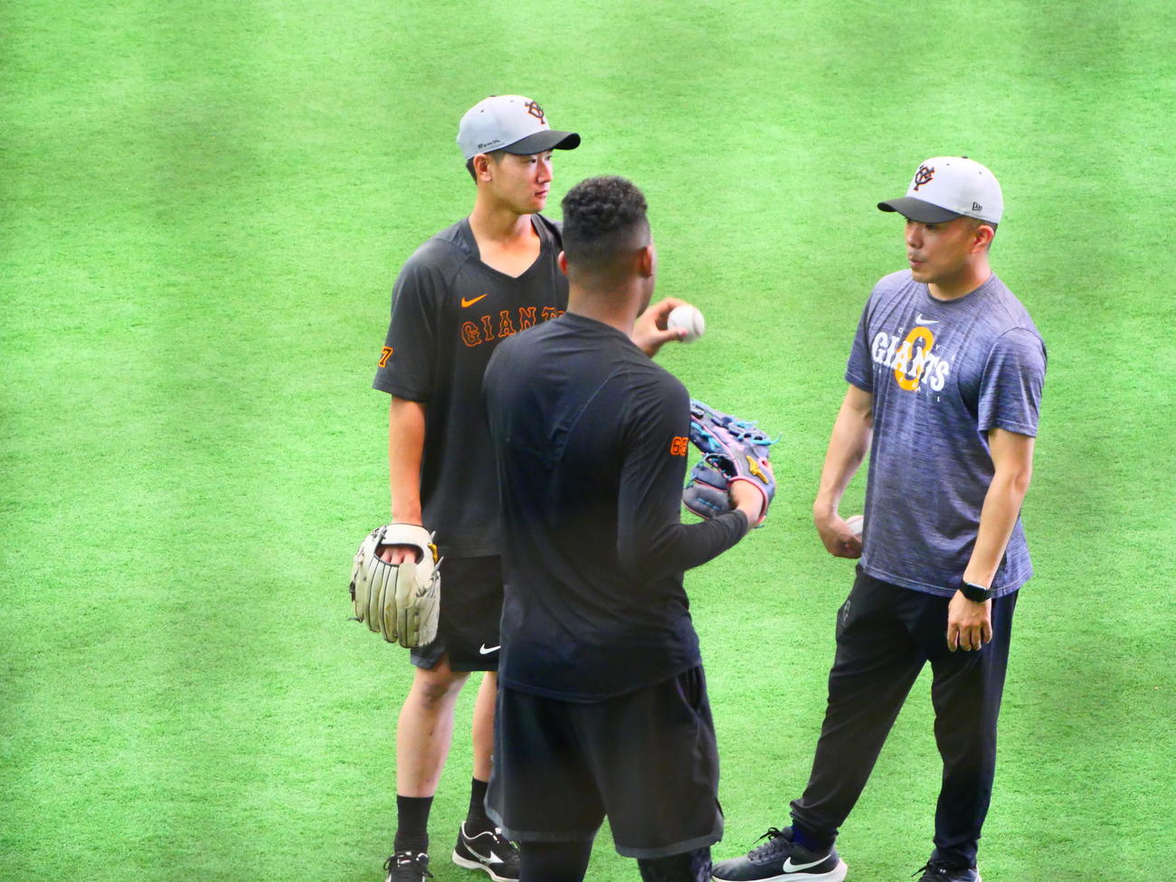 5日、巨人井上（左）にチェンジアップを伝授するメンデス（手前）（撮影・上田悠太）