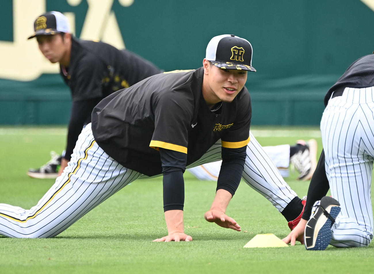 笑顔でウオームアップする佐藤輝（撮影・和賀正仁）