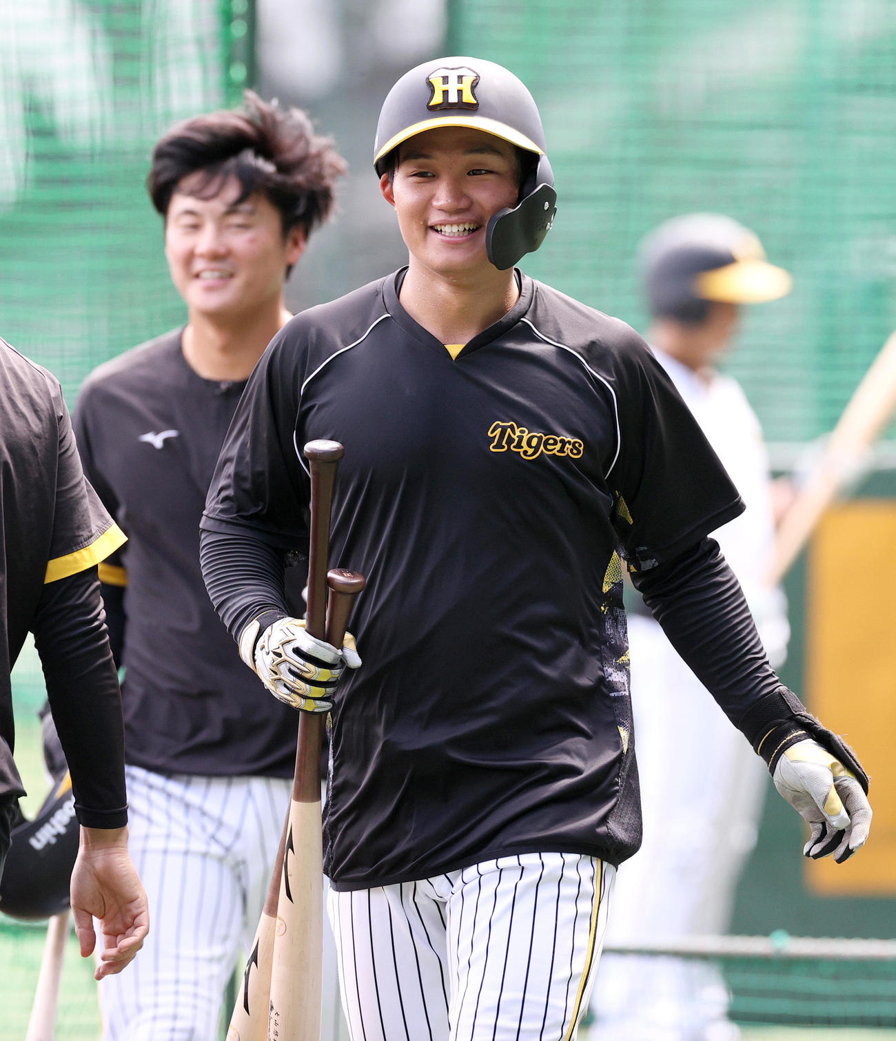 阪神対中日　試合前の練習で、リラックスした表情を見せる阪神森下（手前）。左は前川（撮影・上山淳一）