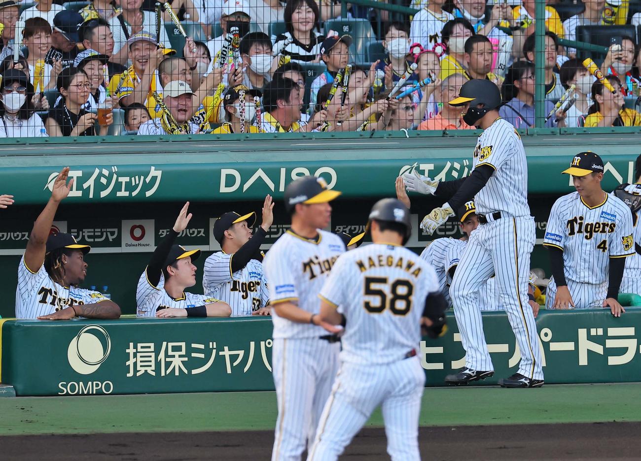 阪神対中日　1回裏阪神1死三塁、前川（手前）の右前先制適時打で生還しナインとハイタッチをする森下（撮影・上田博志）