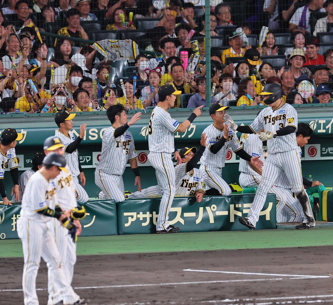 阪神対中日　4回裏阪神2死一、二塁、梅野の中前勝ち越し適時打で生還した大山（右）をハイタッチで出迎える阪神ナイン（撮影・上田博志）