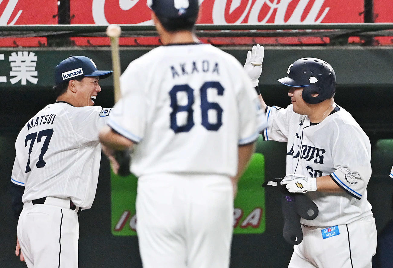 西武対日本ハム　9回裏西武1死二塁、サヨナラの二塁打を放った中村（右）は松井監督とタッチをかわす（撮影・滝沢徹郎）