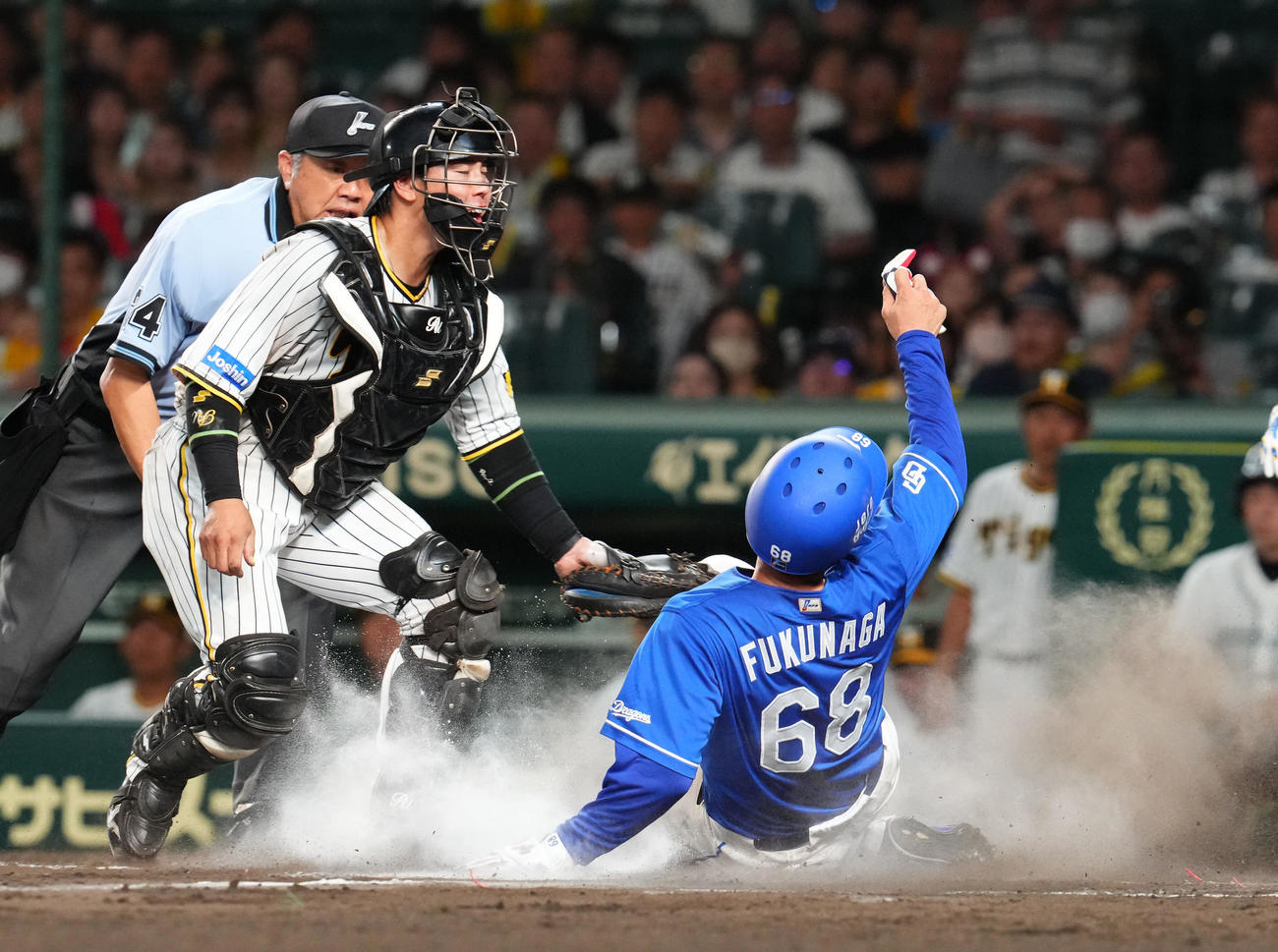阪神対中日　10回表中日2死一、二塁、大島の右前適時打と阪神失策で生還する一走福永。捕手梅野（撮影・藤尾明華）