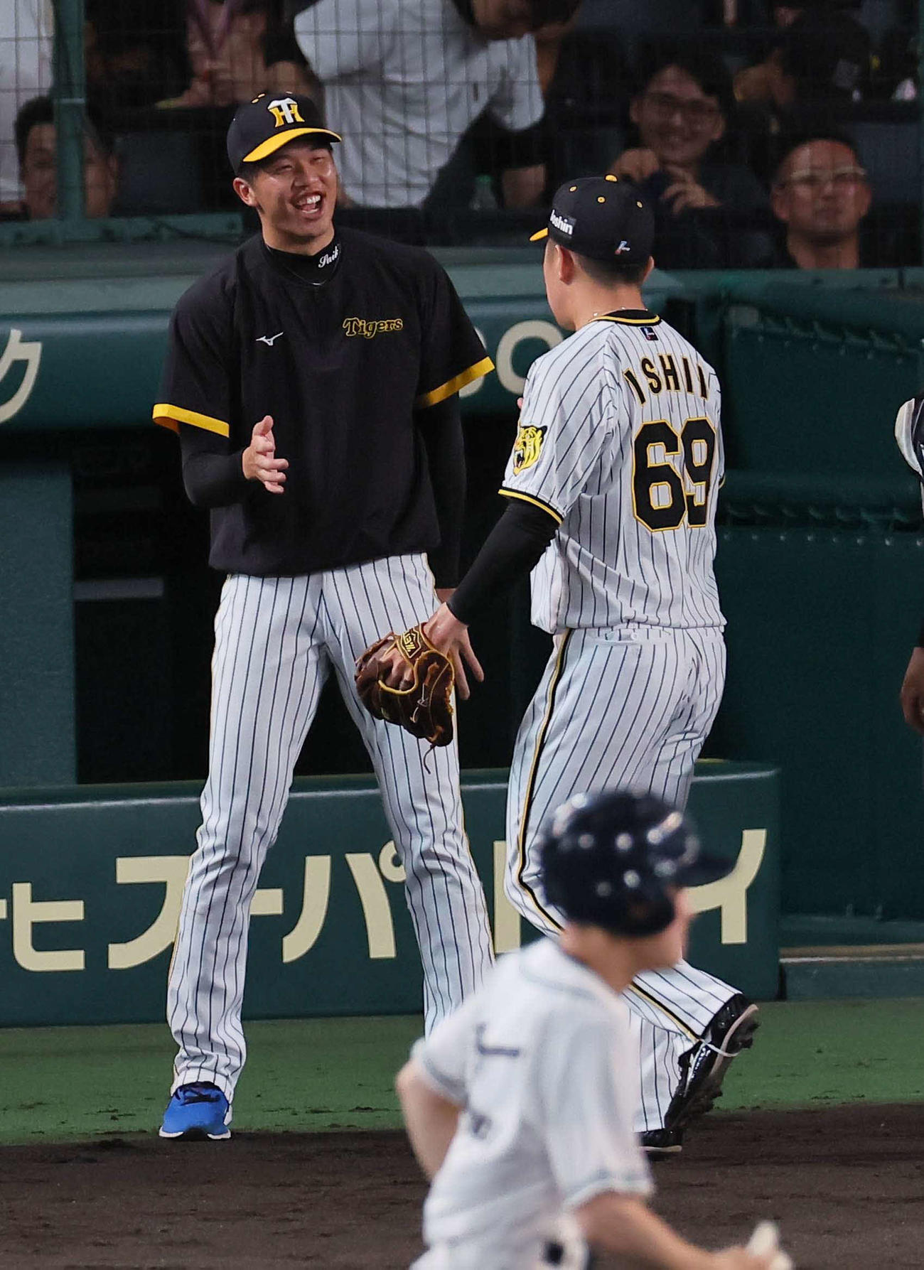 阪神対中日　8回を無失点に抑えた石井（右）を笑顔で出迎える才木（撮影・上田博志）