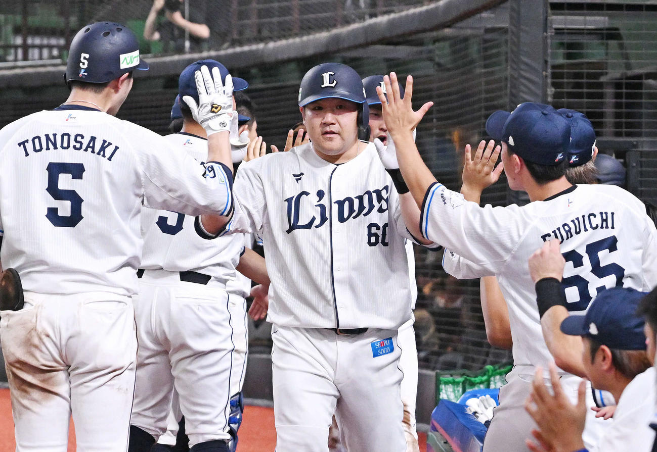 西武対日本ハム　5回裏西武2死一塁、先制2点本塁打を放った中村（中央）はチームメートとタッチをかわす（撮影・滝沢徹郎）