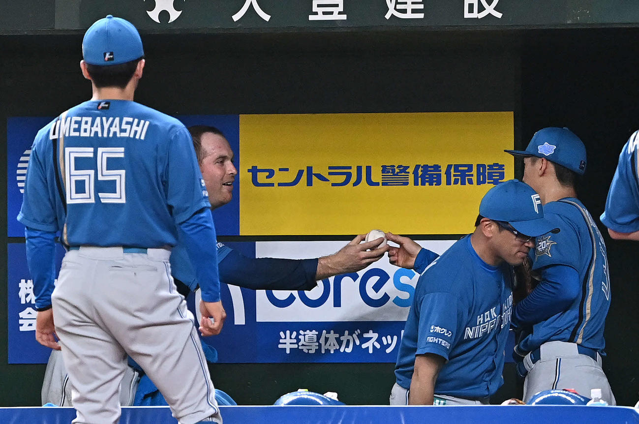 西武対日本ハム　6回裏を投げ終えた日本ハム3番手マーベル（後方左）は加藤豪から記念球を受け取る（撮影・滝沢徹郎）