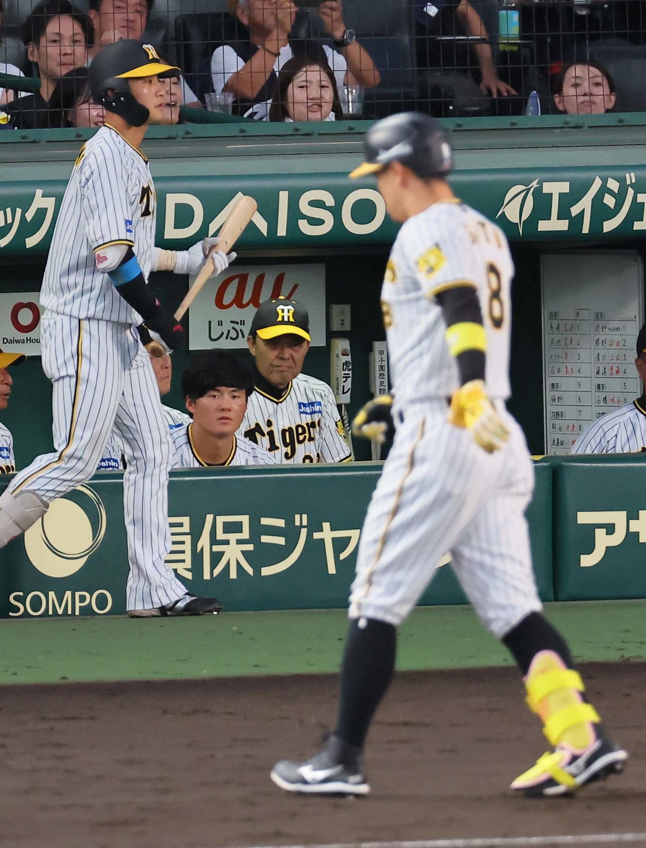 阪神対中日　5回裏阪神無死一塁、中飛に倒れた佐藤輝（右）をベンチ奥から見つめる岡田監督（撮影・上田博志）