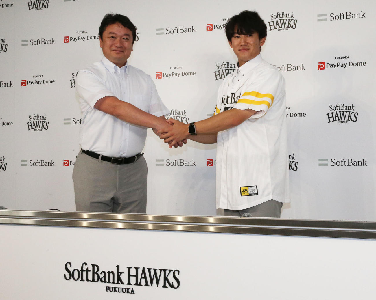 支配下契約会見で握手を交わす三笠取締役GM（左）と木村光（撮影・冨田成美）